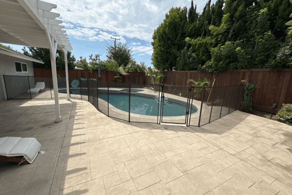 All-Safe black mesh removable pool fence installed around a swimming pool