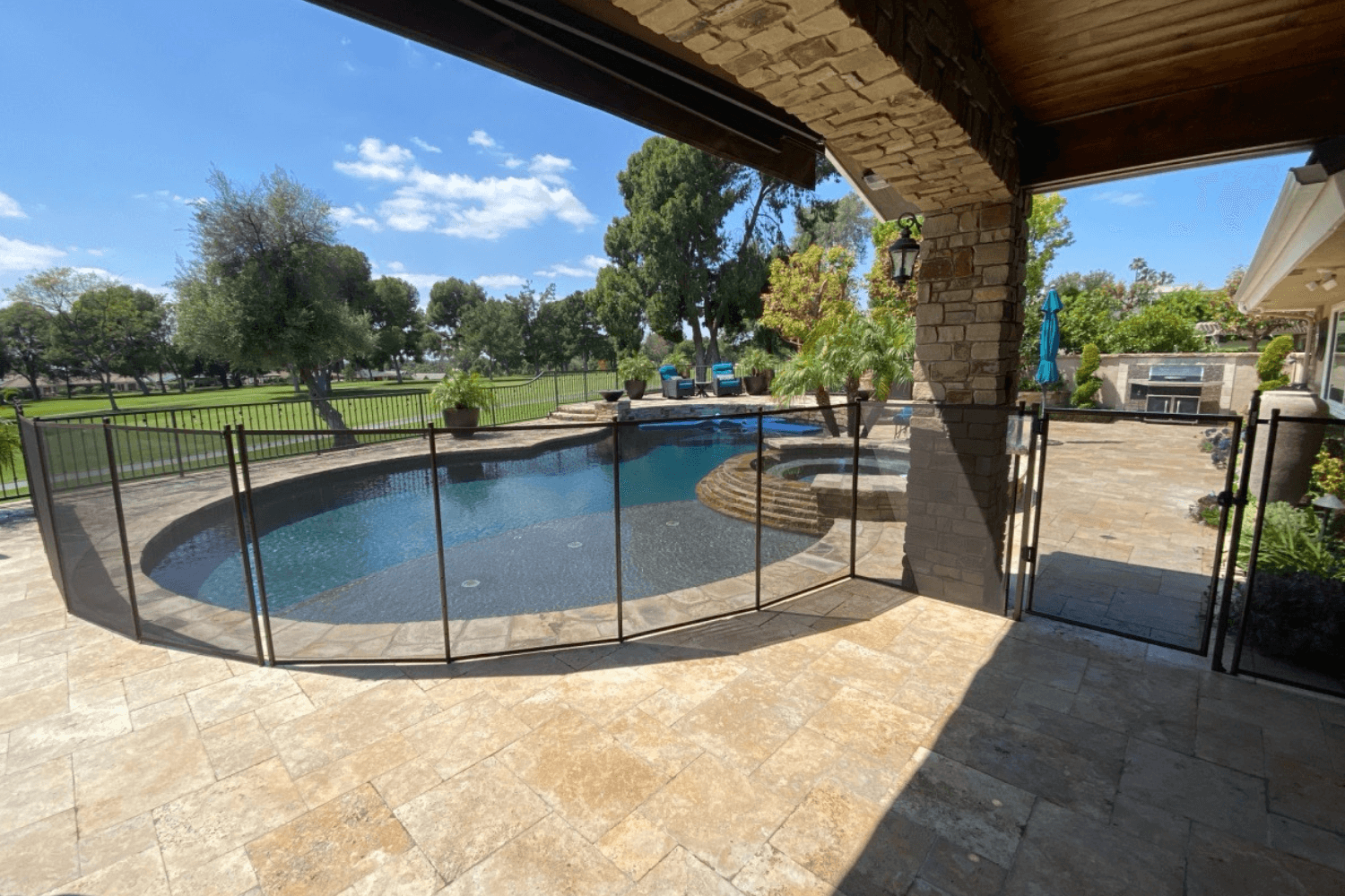 black mesh removable pool fence installed around an irregular shaped pool