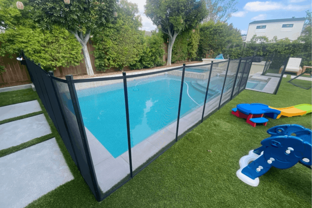 black mesh removable pool fence surrounding a small backyard swimming pool
