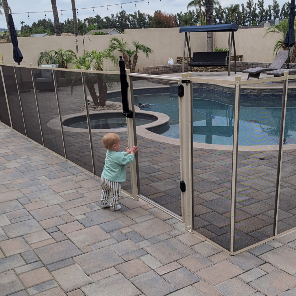 removable mesh pool safety fence installed around residential pool with a Child