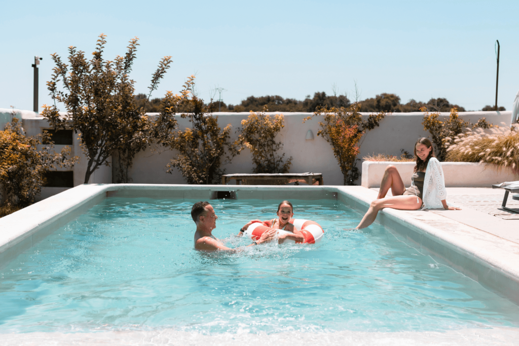 Man, Woman, and child in a swimming pool together.