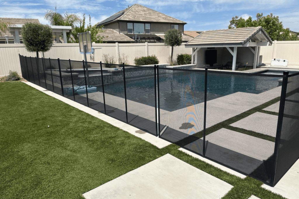 Removable mesh pool fence in black installed around a swimming pool