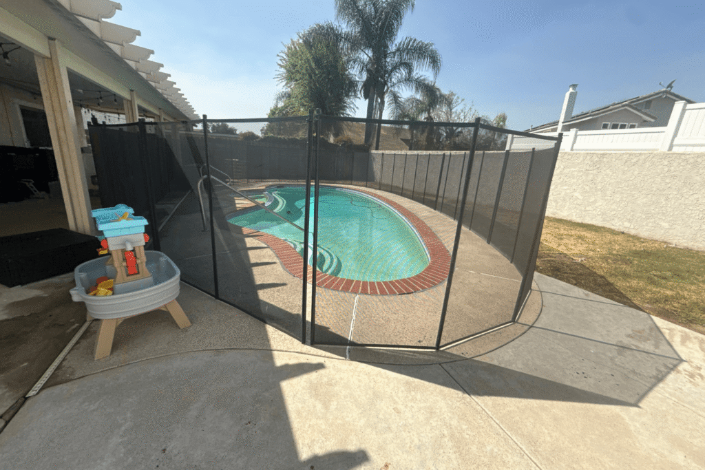 black mesh pool fence surrounding a small swimming pool