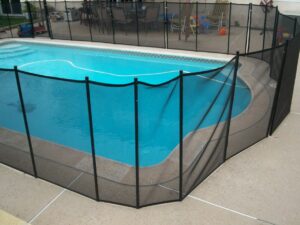black mesh pool fence surrounding a swimming pool that was poorly installed by a DIYer