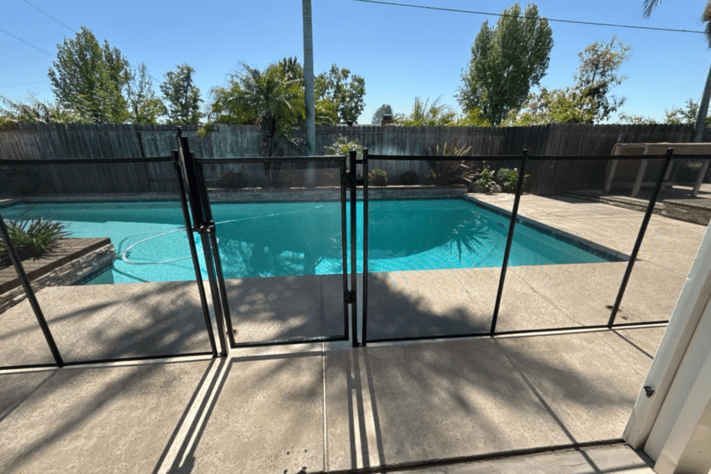 black mesh removable pool fence with a self closing self latching gate