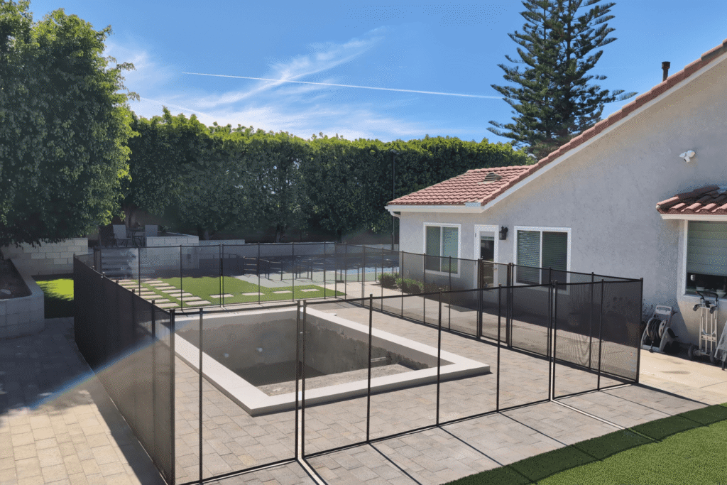 black mesh pool fence surrounding a new pool build in a California backyard