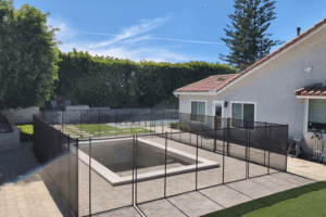 black mesh pool fence surrounding a new pool build in a California backyard