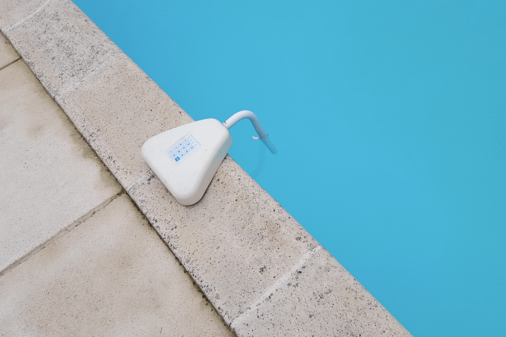 White pool alarm sitting on the edge of a swimming pool