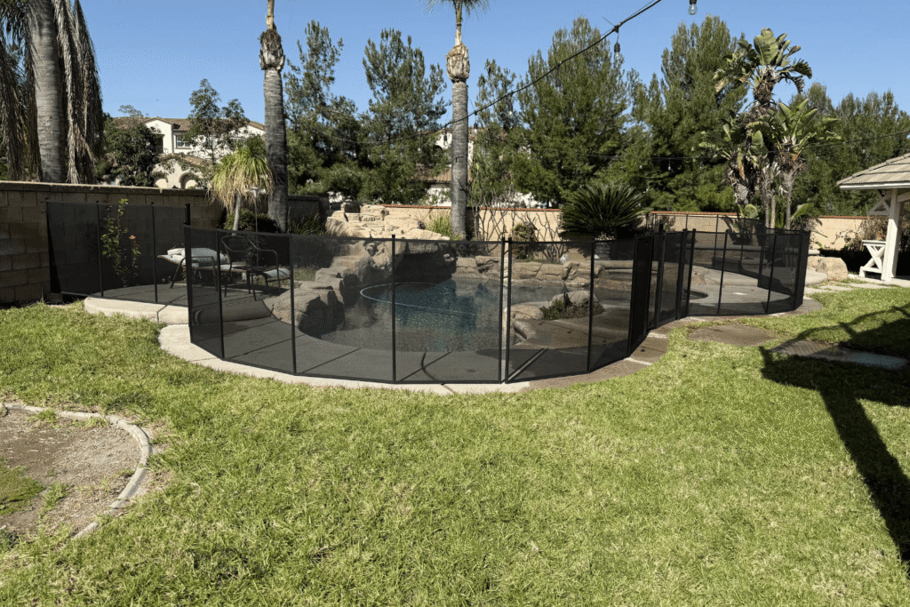 beautiful backyard with a black removable pool fence installed