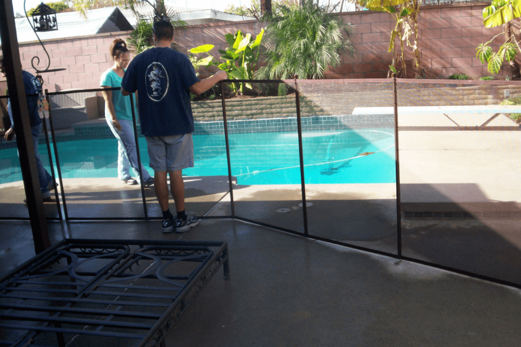 pool owners inspecting their mesh pool fence for safety