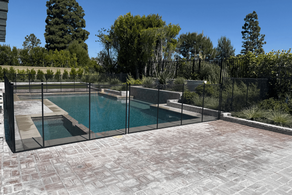 black mesh safety pool fence surrounding a swimming pool