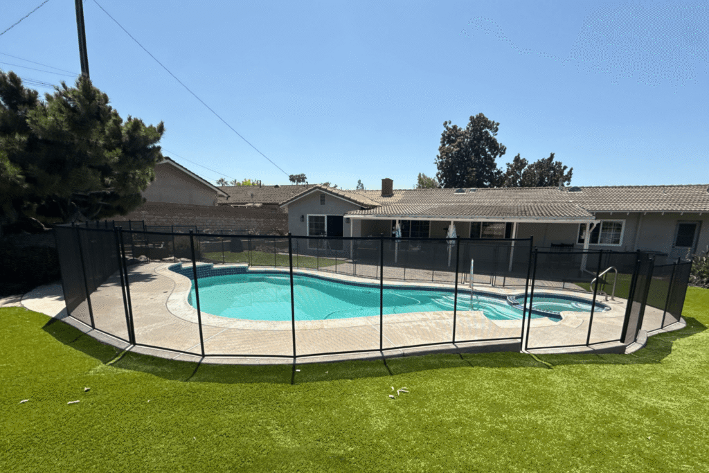 All-Safe black mesh removable pool fence installed around an irregular shaped pool