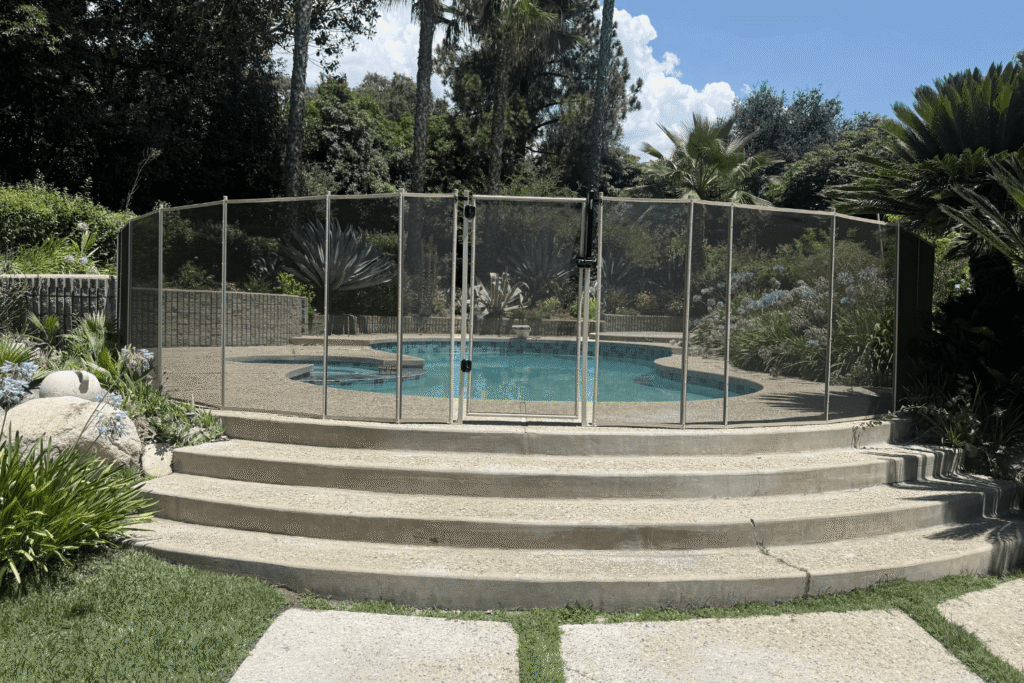All-Safe white mesh removable pool fence installed in a backyard