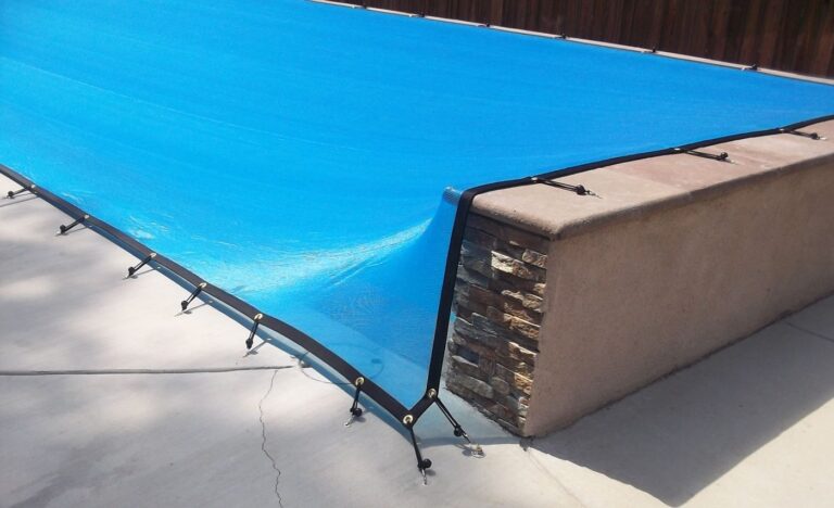 Blue leaf cover clipped to deck anchors with bungee straps, no net underneath