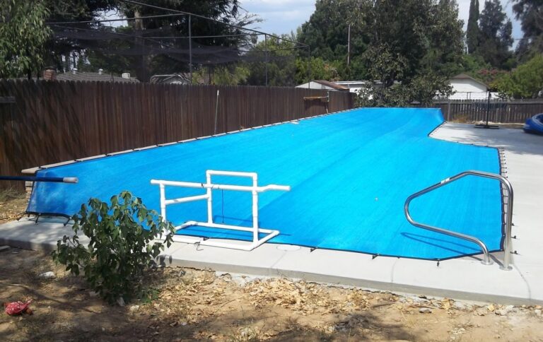 Blue leaf cover over a long pool with a handrail and roller