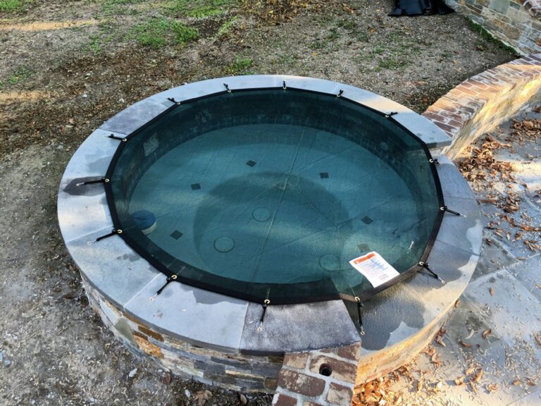 Leaf cover over a round raised stone spa