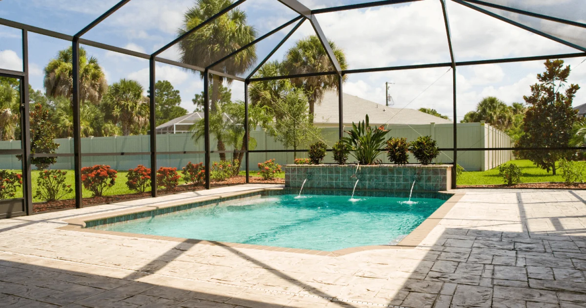 Backyard swimming pool with a screen enclosure around it