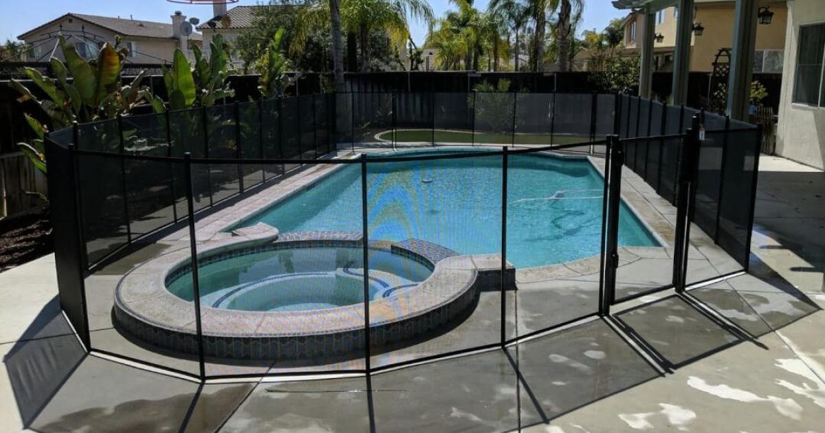 Black mesh pool fence around backyard pool