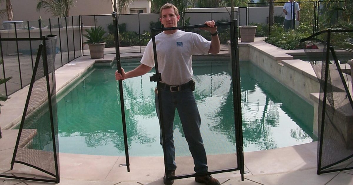 Man disassembling a removable mesh pool fence