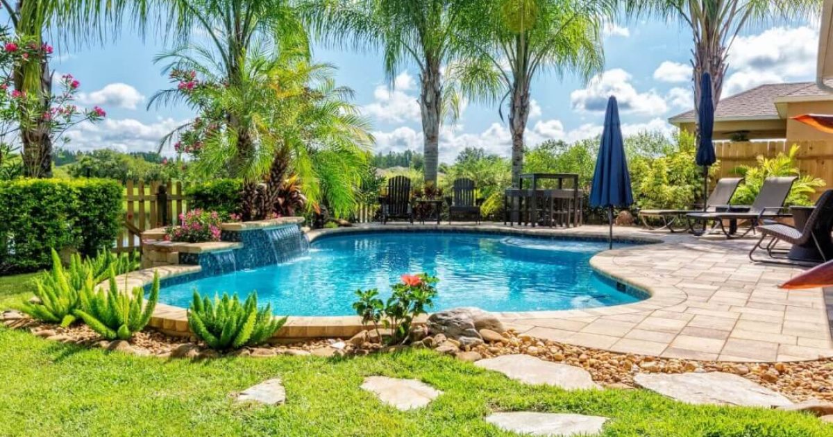 Residential backyard with an irregular shaped swimming pool