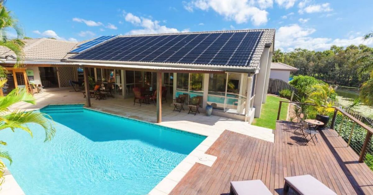 Wooden deck surrounding a backyard swimming pool with clear blue water