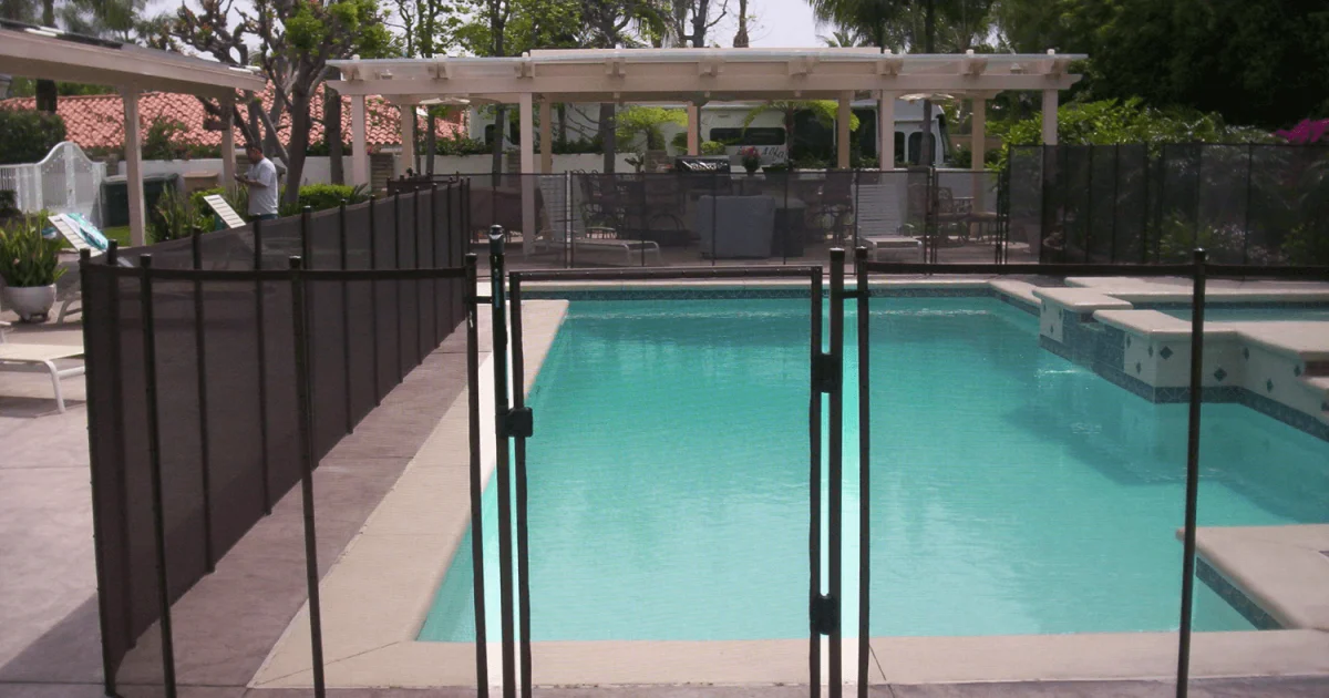 black mesh pool fence installed around a rectangular swimming pool
