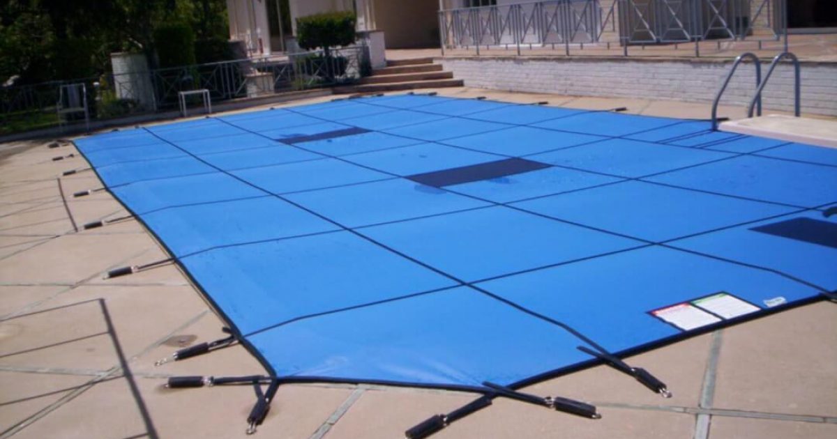 Blue winter pool safety cover secured on a small swimming pool