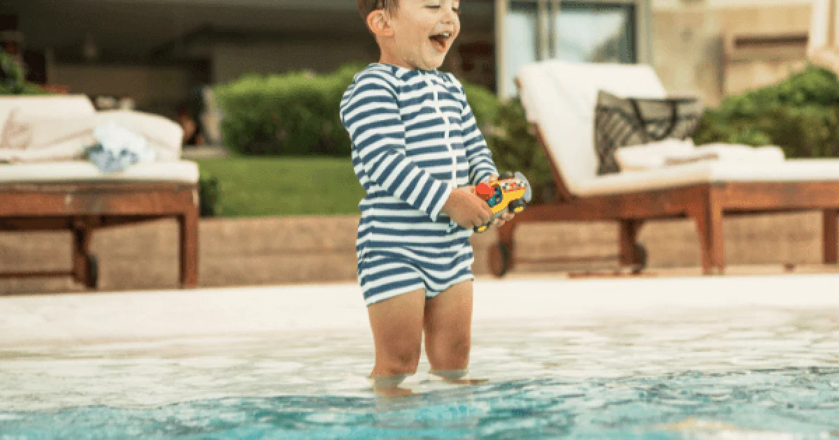 toddler in pool with a toy