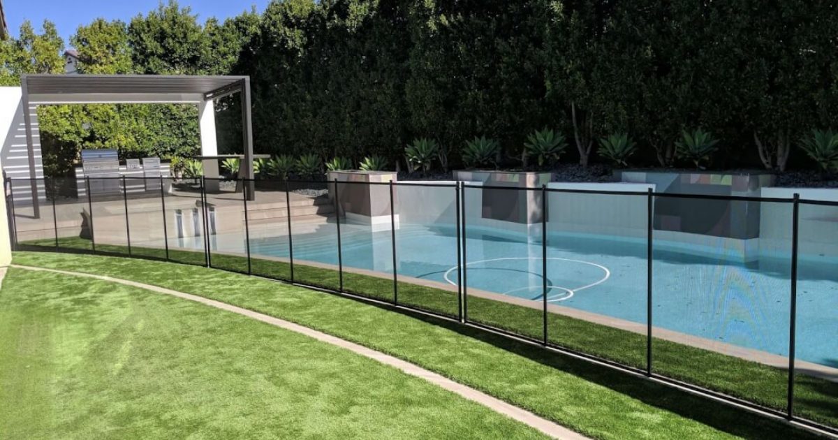 Black mesh removable pool fence installed around a rectangular swimming pool