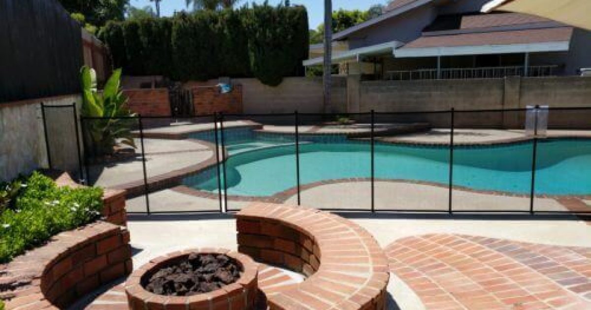 black mesh pool fence installed on irregular shaped backyard pool