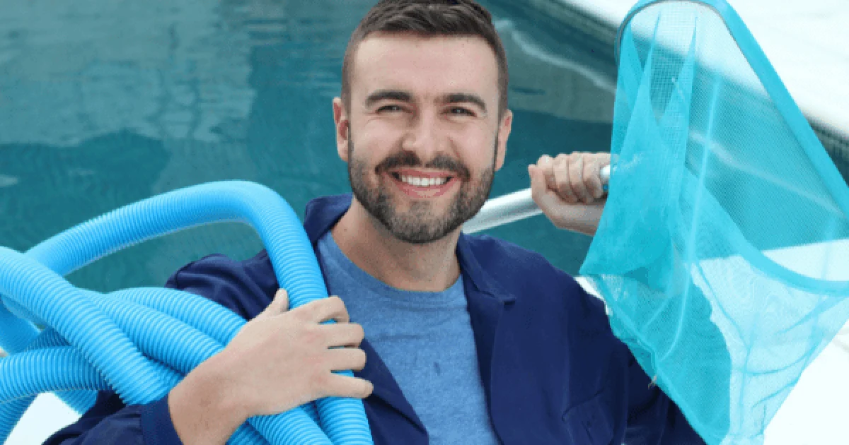 man in a blue shirt holding a pool pump and pool net