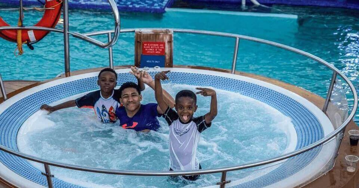 three kids in a hot tub having fun