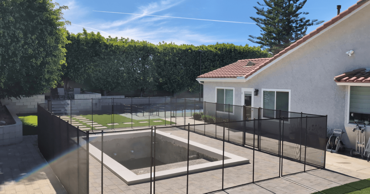 black mesh pool fence surrounding a new pool build in a California backyard