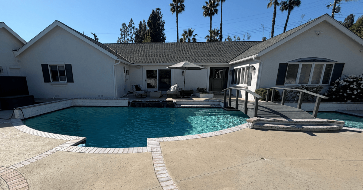 Backyard swimming pool with a bridge across the middle