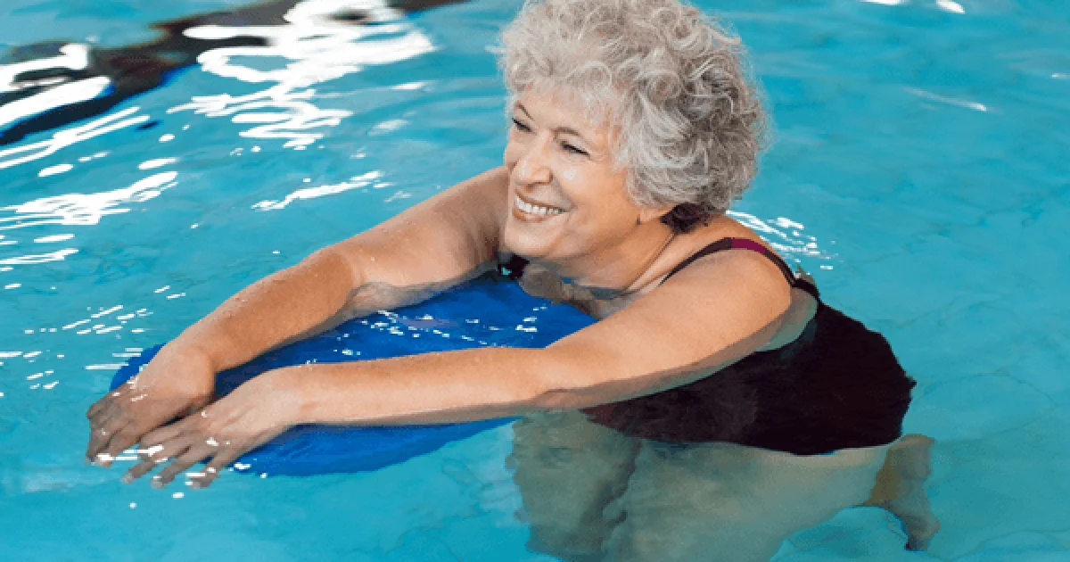 Senior woman floating on a flotation device in a pool