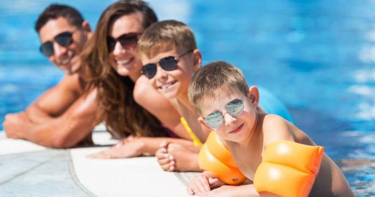 A family poses for a photo while in the swimming pool