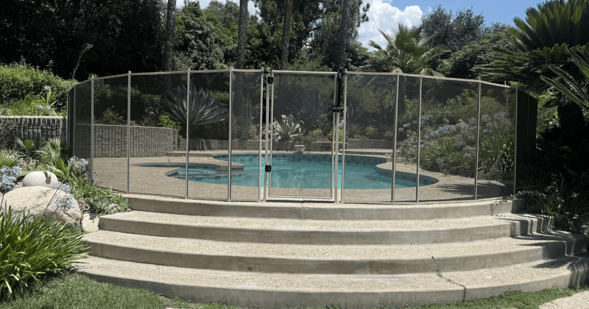 All-Safe white mesh removable pool fence installed in a backyard