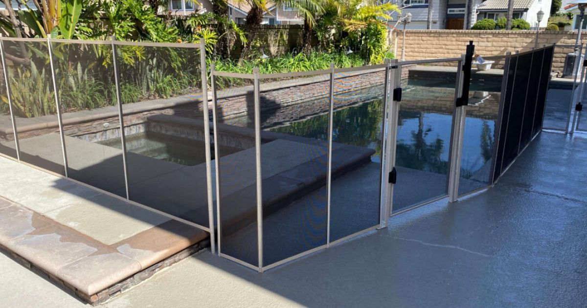 white mesh pool fence installed around a swimming pool